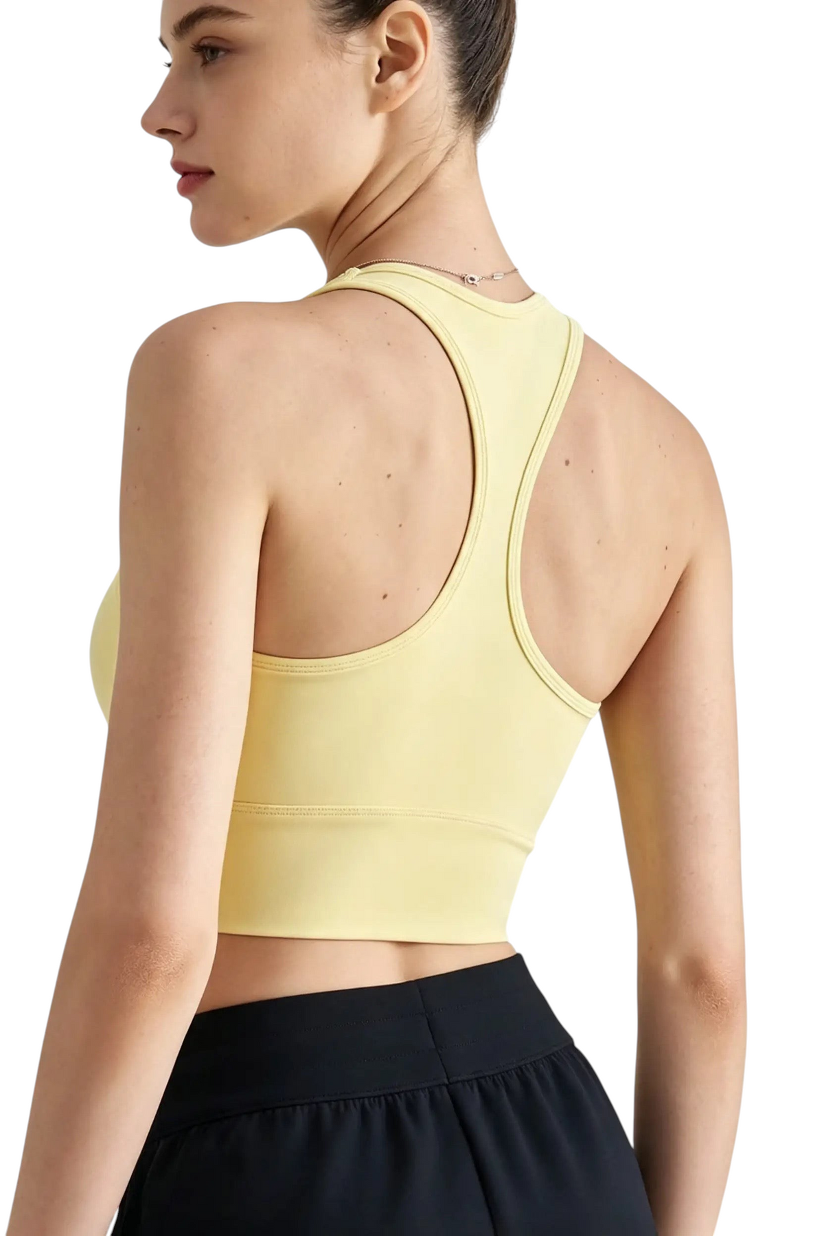 Modèle portant une brassière de sport jaune JOY-STYLE Active Sculpt avec dos nageur, vue de dos sur fond blanc