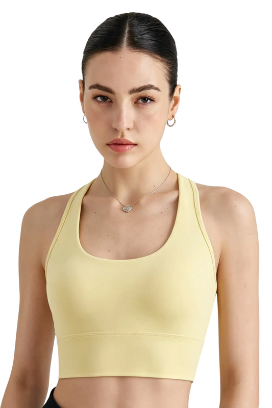 Modèle portant la brassière de sport jaune pâle JOY-STYLE Active Sculpt avec encolure arrondie et coupe ajustée