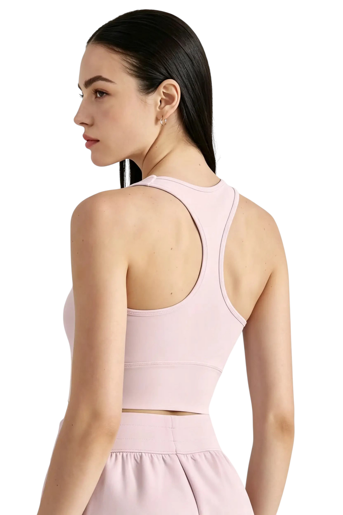 Modèle portant une brassière de sport rose pâle JOY-STYLE avec dos nageur pour un maintien optimal lors du fitness